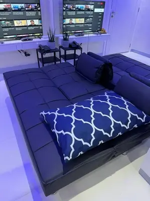 a blue bed in a room with two tables at The Quin Place 1BR 200Mbps WIFI in Manila