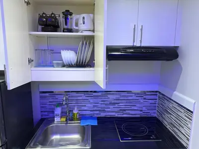 a kitchen with a sink and a stove at The Quin Place 1BR 200Mbps WIFI in Manila