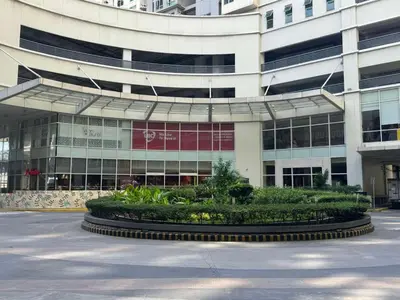 a large building with a garden in front of it at The Quin Place 1BR 200Mbps WIFI in Manila