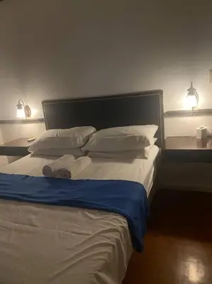 a bedroom with a large bed with two lamps on it at Fernandina 88 Suites Condo in Manila