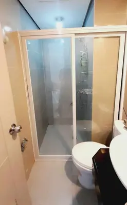 a bathroom with a shower with a toilet and a sink at Newport City Family Suite near NAIA T3 in Manila