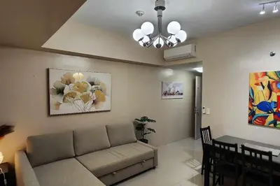 a living room with a couch and a dining room at Newport City Family Suite near NAIA T3 in Manila
