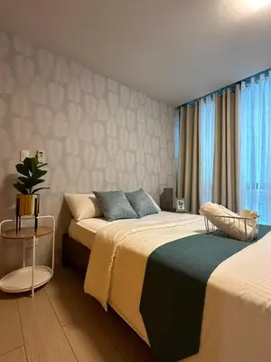 a bedroom with two beds and a chair at BGC One Uptown Suite by Christine Suites PH in Manila