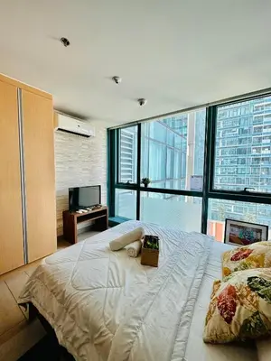 a bedroom with a large bed with a large window at BGC One Uptown Suite by Christine Suites PH in Manila
