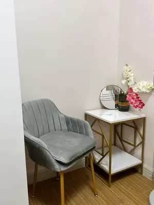 a gray chair next to a table with a side table at Cozy Condo in Taguig in Manila