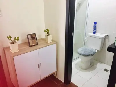 a bathroom with a toilet and a shower with a picture at Lovely two bedroom apartment with balconies in Manila
