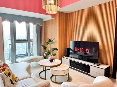 a living room with a tv and a couch and a table at Elegant 4BR with balcony and bathtub in Uptown BGC in Manila