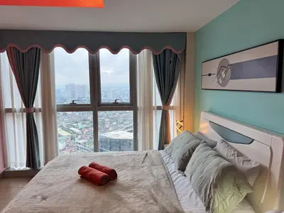 a bedroom with a large bed with a large window at Elegant 4BR with balcony and bathtub in Uptown BGC in Manila