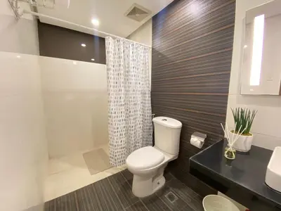 a bathroom with a toilet and a shower and a sink at UPad Hotel in Manila