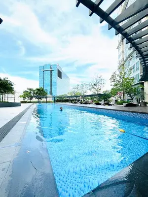 a large swimming pool with a building in the background at Hayahay Rentals in Manila