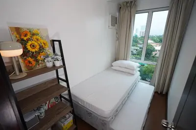 a small room with a bed and a window at Hayahay Rentals in Manila