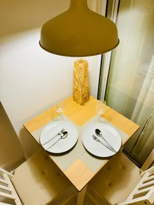 a table with two white plates and a lamp at Masies Beach View Suite at Azure Urban Resort Residences in Manila