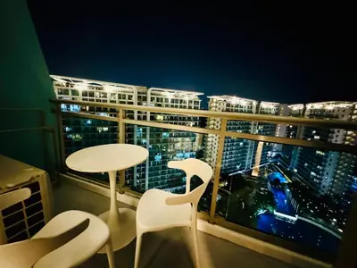 a table and chairs in a balcony with a view of a city at Masies Beach View Suite at Azure Urban Resort Residences in Manila
