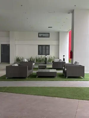 a lobby with couches and grass in a building at Quiet Oasis in Bloom Residences in Manila