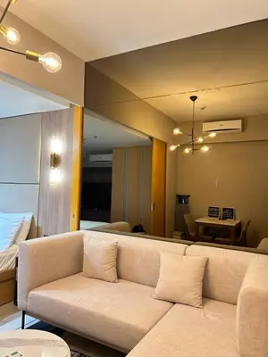 a living room with a couch and a bed at One Uptown Residences BGC in Manila