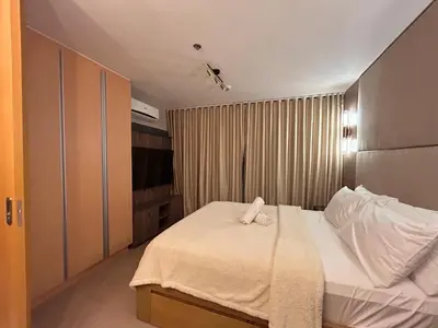 a hotel room with a bed with a towel on it at One Uptown Residences BGC in Manila