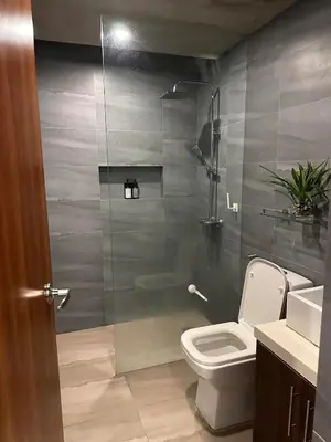 a bathroom with a toilet and a glass shower at Cozy Spacious Pet Friendly Unit with Netflix Pool Gym in Manila