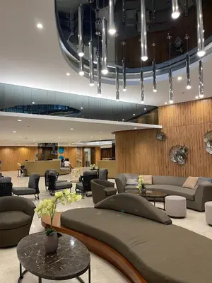 a lobby with couches and tables in a building at Premium Condotel Close To MOA in Manila