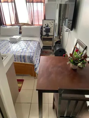 a small room with two beds and a table at Pierrecondotel in Manila