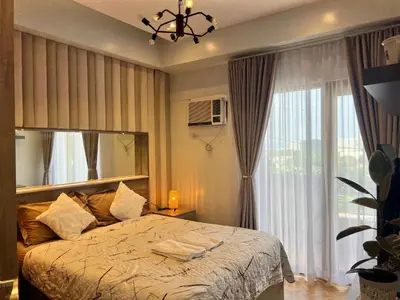a bedroom with a bed and a large window at 1 Bedroom Penthouse Condo Near Airport NAIA in Manila