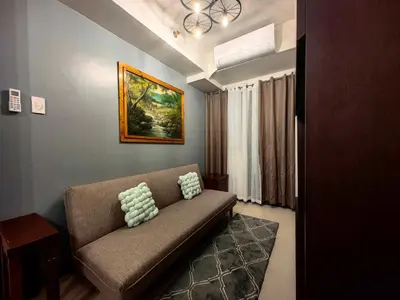 a living room with a couch with two pillows on it at Casa R and R Cozy Staycation at S Residences in Manila