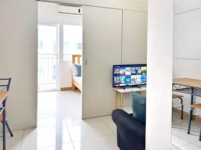 a living room with a television and a table and chairs at 1-Bedroom Condo in Las Piñas in SM SouthMall in Manila