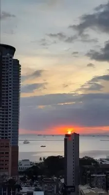 a sunset over a city with buildings and the ocean at COMFY 1-BR Condo near SLEC, US Embassy, Malls,Park in Manila