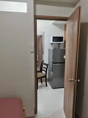 a room with a door to a kitchen with a microwave at Mall of Asia Pasay Shore 3 Residence in Manila