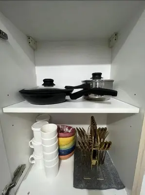 a kitchen shelf with a pan and dishes on it at POEA Mega Mall WiFi Netflix in Manila
