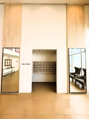 a hallway with two mirrors and a chair in a building at JFam Suites, C1-5L 1BR , Up To 7 Pax in Biñan