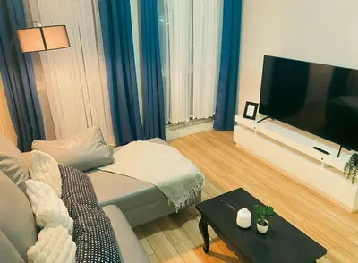 a living room with a couch and a flat screen tv at JFam Suites, C1-5L 1BR , Up To 7 Pax in Biñan