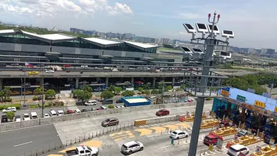 a parking lot with cars parked in front of a building at Condotels near and across Terminal3 Airport in Manila