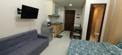 a living room with a couch and a television in it at Condotels near and across Terminal3 Airport in Manila