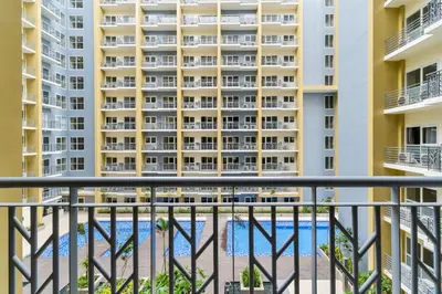 an apartment balcony with a view of a building at Ocean View Condo with Infinity Pool, Gym, Spa - Next to Okada, Solaire & MOA in Manila