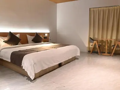 a bedroom with a large bed and a table at Terra Hotel Kawit in Kawit