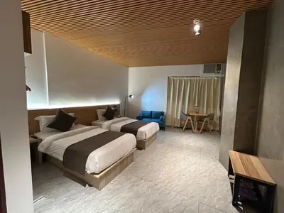 a hotel room with two beds and a table at Terra Hotel Kawit in Kawit