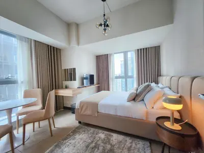a bedroom with a bed and a desk and a table at LUXESTAYSMNL STYLISH FAMILY 2BR SUITE POOLGYM 400MBPS WIFI NETFLX Amazing City View in Manila