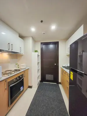 a kitchen with a black door and a black oven at LUXESTAYSMNL STYLISH FAMILY 2BR SUITE POOLGYM 400MBPS WIFI NETFLX Amazing City View in Manila