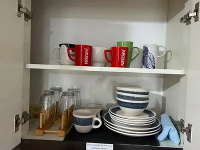 a cupboard with plates and cups and mugs at Solstay in Manila
