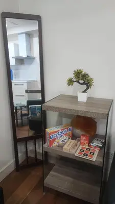 a book shelf with books and a bonsai tree on it at Aveline Suites, Garden City view, 2br, amenities in Manila
