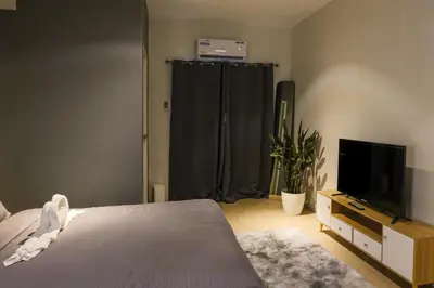 a bedroom with a bed and a flat screen tv at Siesta Spaces Adela in Manila