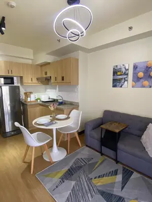 a living room with a blue couch and a table at Brixton place near bgc in Manila
