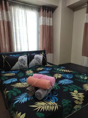 a bed with two towels on top of it at LDN Studio Unit Two Palm Tree in Manila