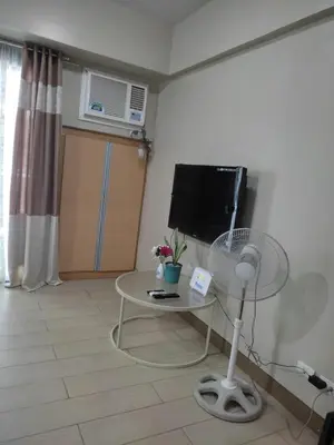 a living room with a table and a tv at LDN Studio Unit Two Palm Tree in Manila