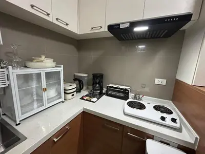 a kitchen with a stove and a counter top at Cozy 1BR with BGC View Gym and Pool Included in Manila