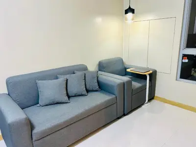 a blue couch with pillows in a living room at Cozy 1BR with BGC View Gym and Pool Included in Manila