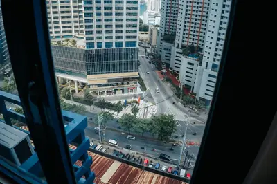 a view of a city street from a window at The House of Five - Brand New Hotel Style Condo in Manila