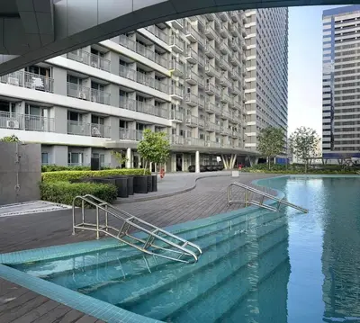 a pool of water in front of a building at Casa Jezhuel at Fame Residences in Manila