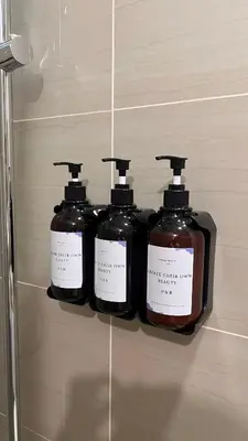 three bottles of soap on a shelf in a bathroom at Lemmon's Casita in Manila