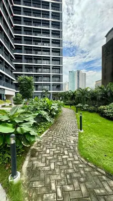 a brick path in front of a tall building at The GoodVibes Condotel Red Residences Makati in Manila